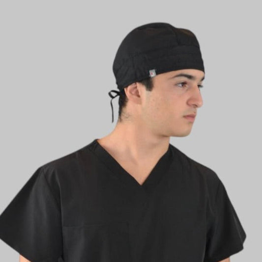 A person wearing a black scrub hat with an adjustable drawstring.